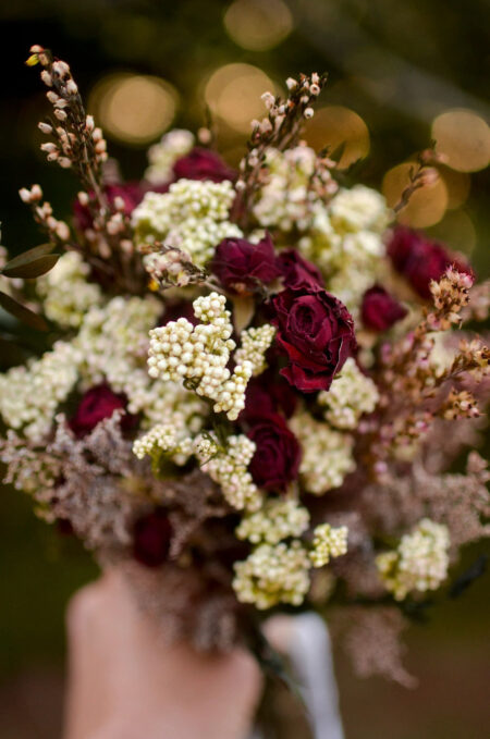 Arrangement with dried burgundy roses